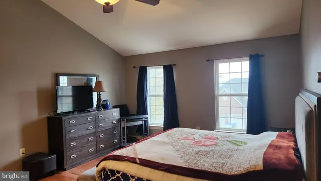 a bedroom with a bed and a flat tv screen on a dresser