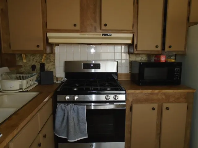 a stove top oven sitting inside of a kitchen