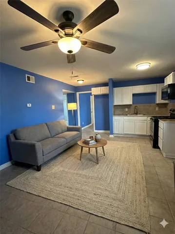 a living room with furniture and kitchen view
