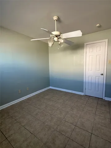 an empty room with a ceiling fan and a window