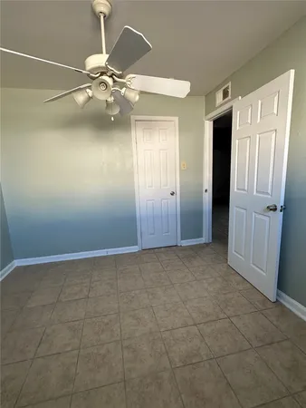 a view of an empty room with a chandelier fan