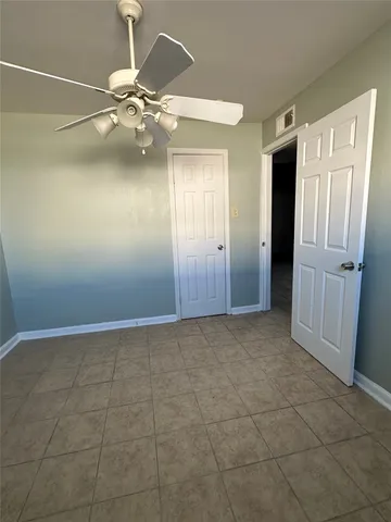 a view of an empty room with a chandelier fan