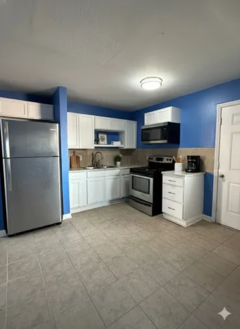 a kitchen with stainless steel appliances and a refrigerator