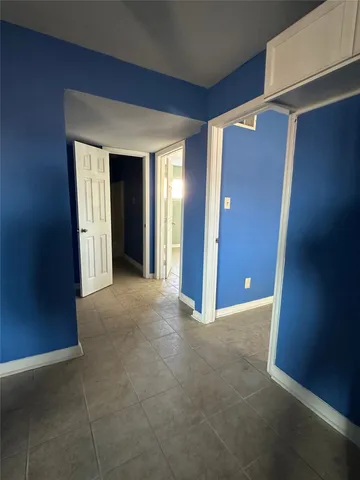 a view of an empty room with closet and wooden floor