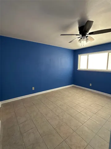 en empty room with windows and ceiling fan