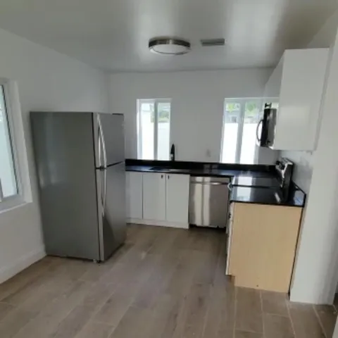 a kitchen with stainless steel appliances a refrigerator and a stove top oven