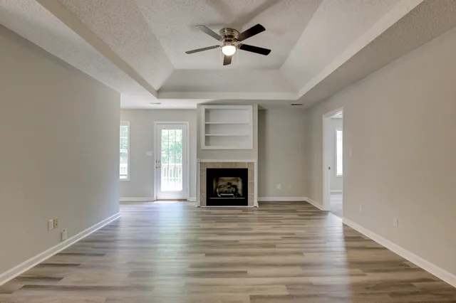wooden floor fireplace and windows in an empty room