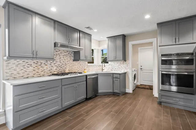 a kitchen with a sink cabinets stainless steel appliances and a counter top space