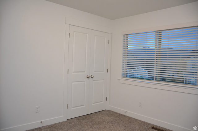 1842 South 1280th Street West Logan, UT 84321 - Photo 17 of 21 Bright room featuring a double-door closet with polished chrome hardware, a window with horizontal blinds, and neutral carpeting