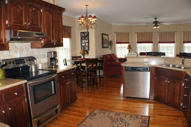128 Hunters Ridge Drive Tullahoma, TN 37388 - Photo 6 of 20 Step into the Kitchen and notice the Gorgeous Custom Cabinets, Tile Back Splash, Hardwood Floors and Solid Surface Counter Tops!