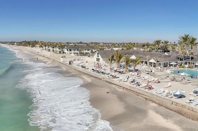 an aerial view of ocean and residential houses with outdoor space