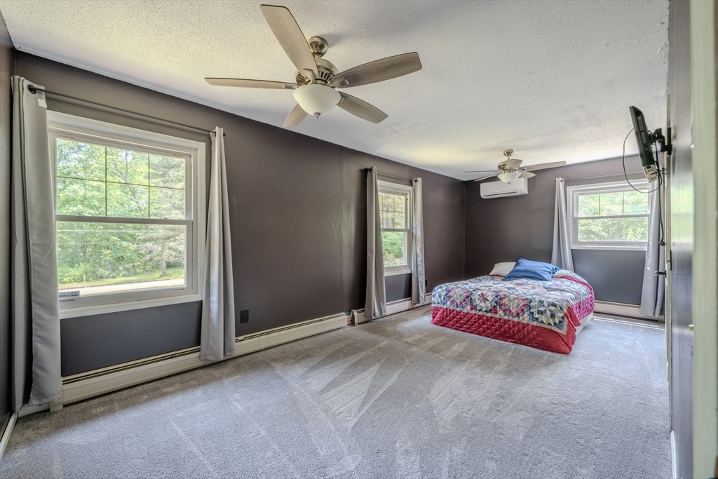 71 Webber Road Brookfield, MA 01506 - Photo 20 of 41 a bedroom with a large bed chandelier and a window