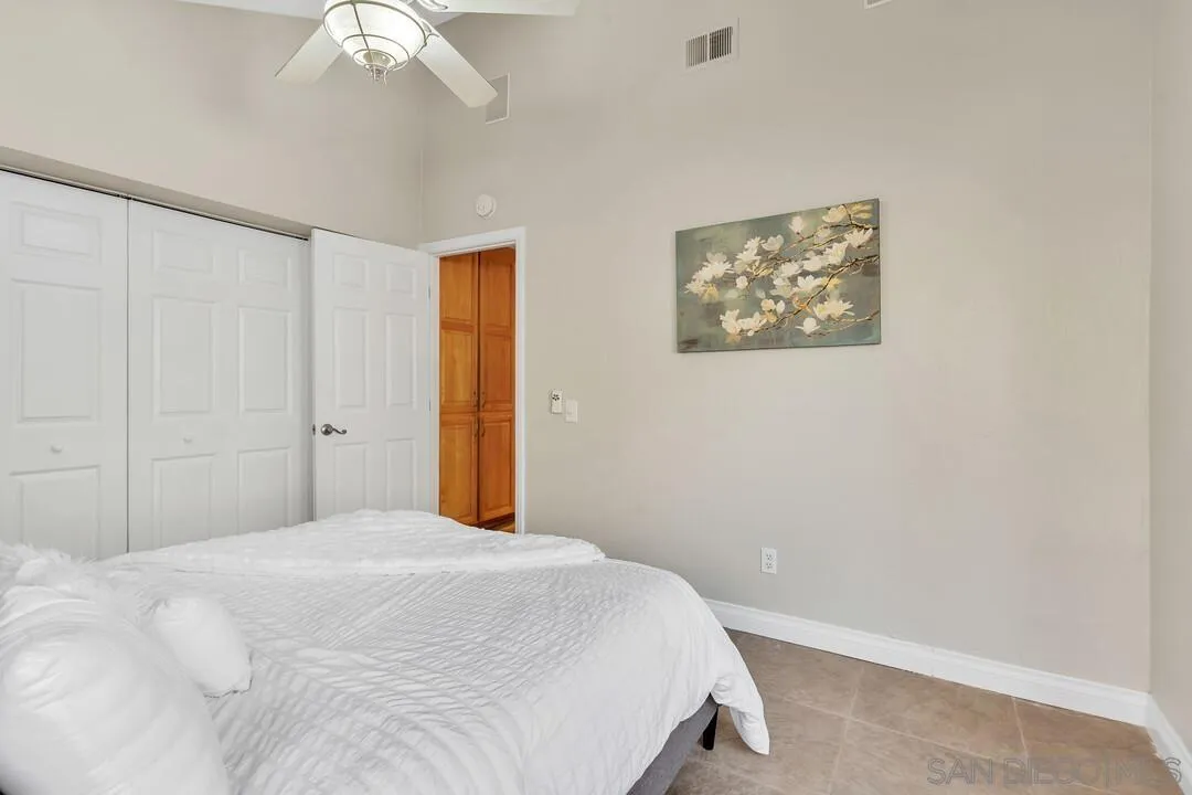 9651 Ramsgate Way Santee, CA 92071 - Photo 17 of 52 a bedroom with a bed and a chandelier