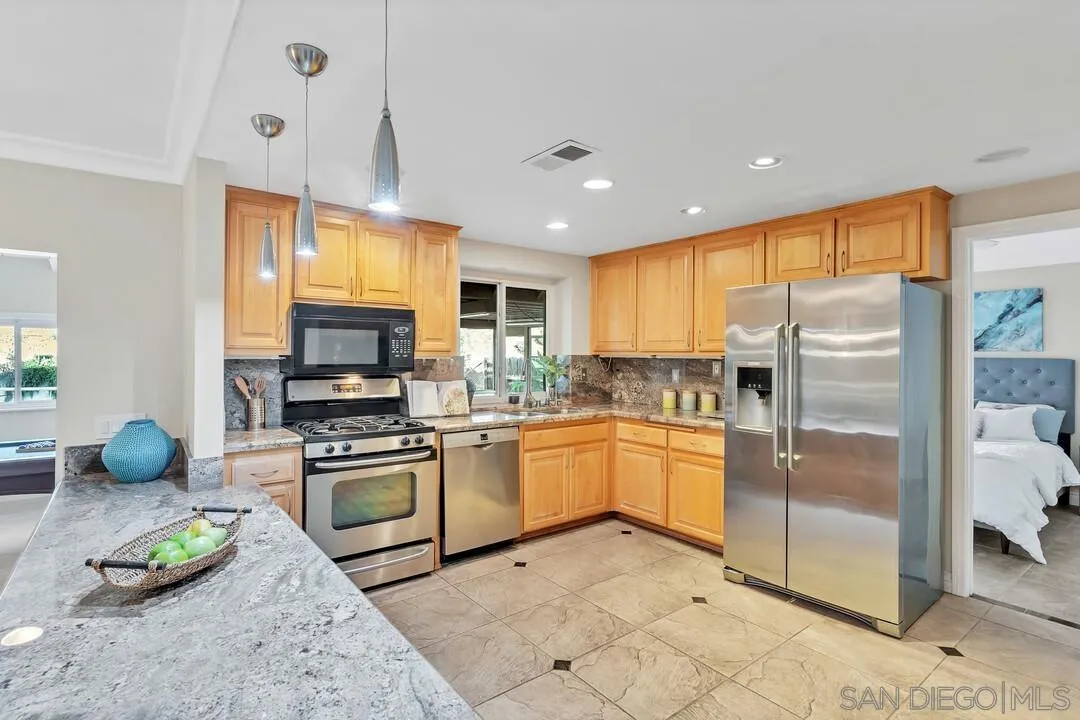 9651 Ramsgate Way Santee, CA 92071 - Photo 9 of 52 a kitchen with stainless steel appliances a stove a sink cabinets and a refrigerator
