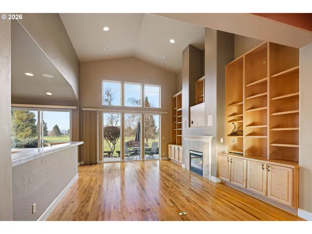 a open kitchen with granite countertop a large window and a wooden floor