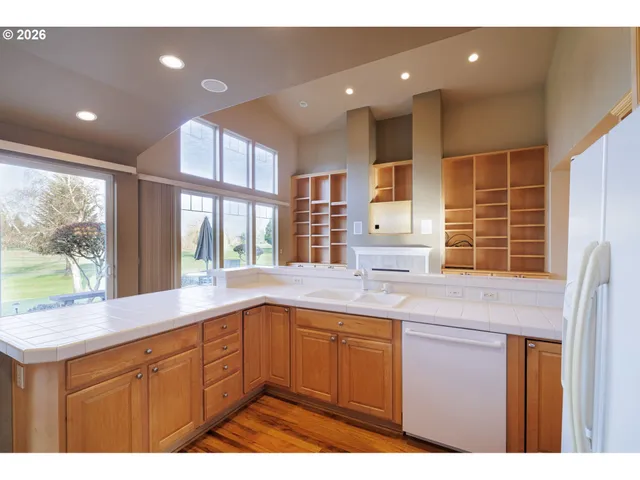 a kitchen with granite countertop a sink window and cabinets