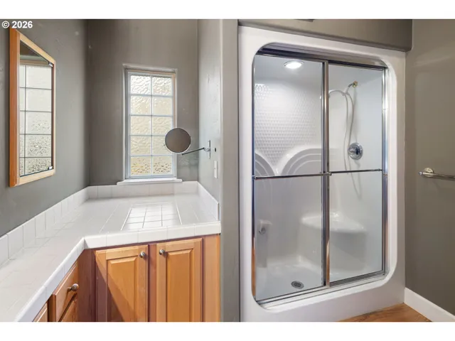 a bathroom with a shower sink and mirror