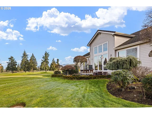 a house view with swimming pool and trees in the background