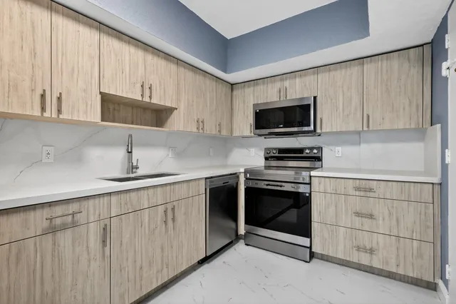 a kitchen with white cabinets and stainless steel appliances