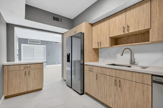 a kitchen with stainless steel appliances granite countertop a refrigerator and a sink