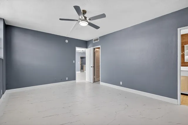a view of an empty room with a ceiling fan