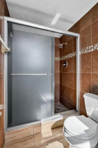 a bathroom with a toilet and a shower