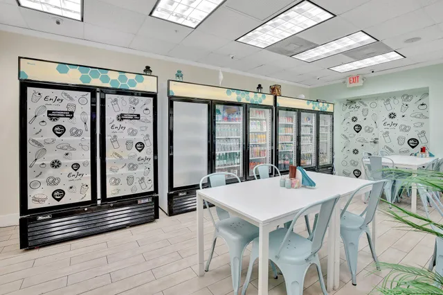 a large white kitchen with stainless steel appliances kitchen island granite countertop a refrigerator and a sink