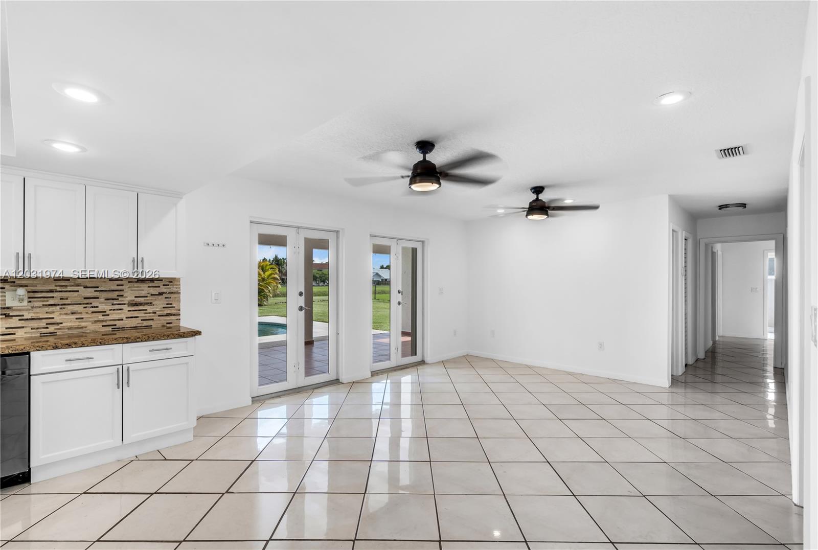 9380 Southwest 134th Street Miami, FL 33176 - Photo 11 of 36 off the kitchen the doors open to the pool/covered patio