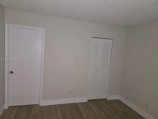 a view of a room that has wooden floor and windows