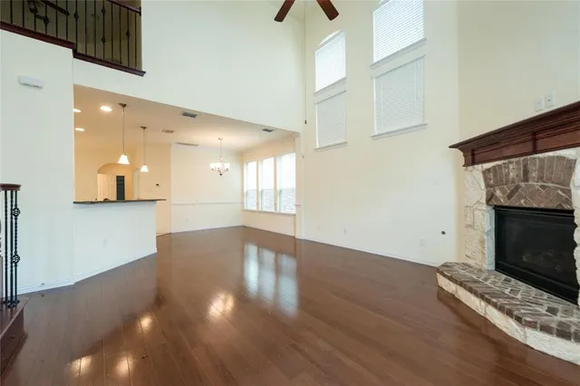 a view of an empty room with wooden floor and a fireplace