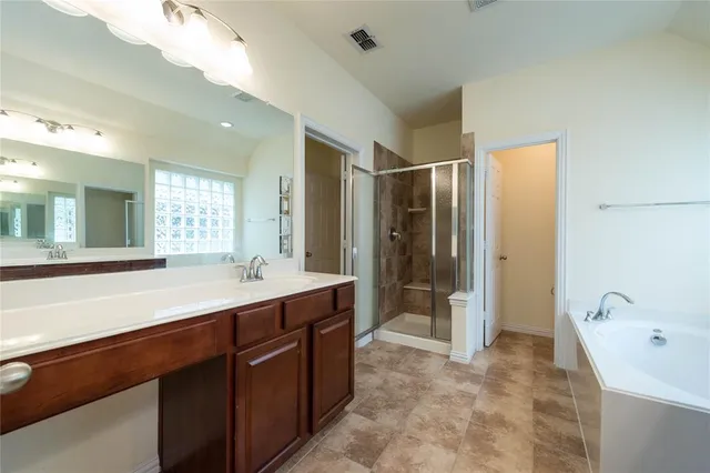 a spacious bathroom with a shower sink and mirror