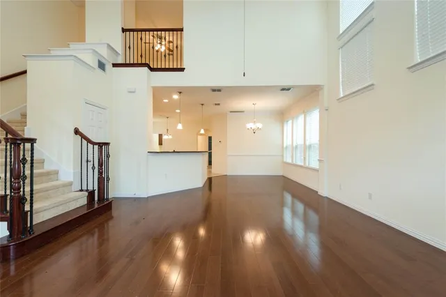 a view of a hallway with wooden floor and cabinet