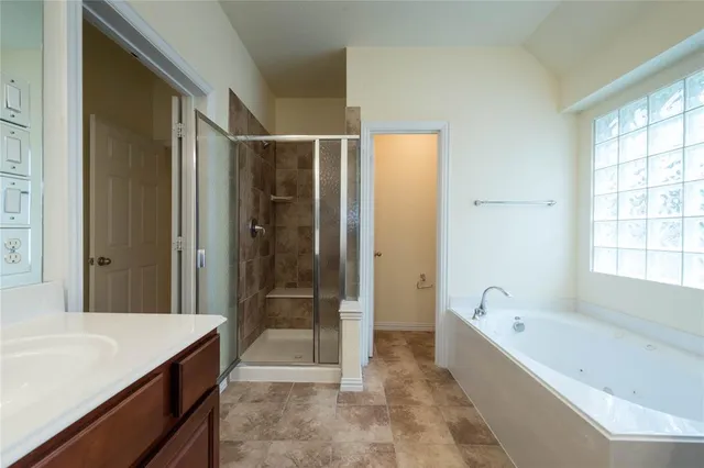 a spacious bathroom with a granite countertop tub shower sink and mirror