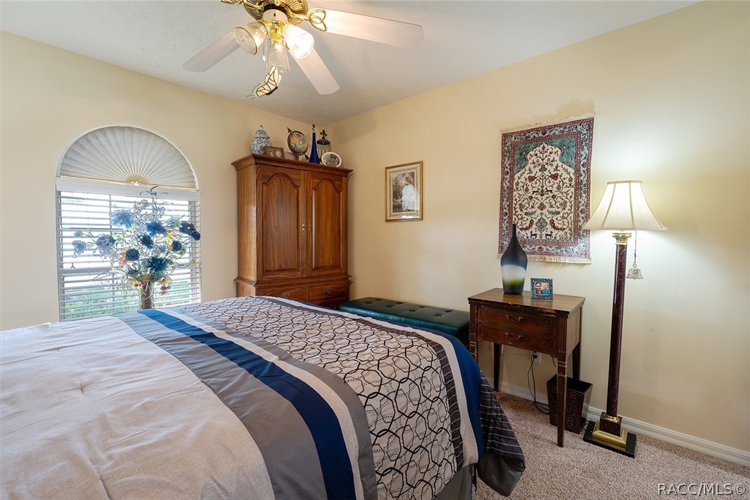 800 Balmoral Court Inverness, FL 34453 - Photo 35 of 72 a bedroom with a bed and a chandelier