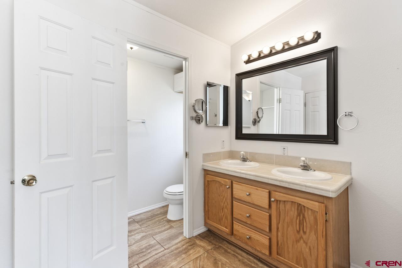 901 6530 Road, Unit 1312 Montrose, CO 81401 - Photo 19 of 30 a bathroom with a toilet sink and mirror