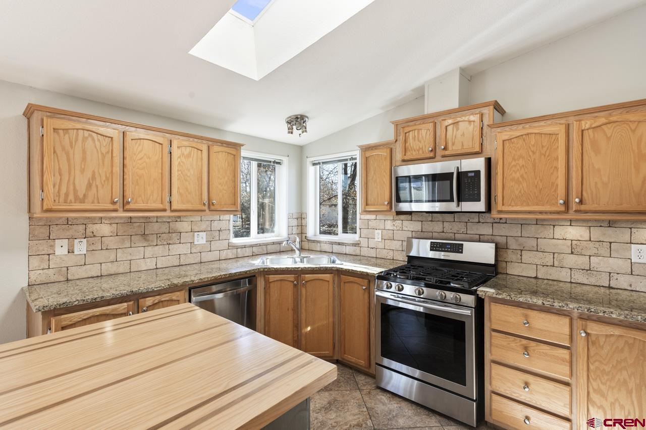 901 6530 Road, Unit 1312 Montrose, CO 81401 - Photo 30 of 30 a kitchen with stainless steel appliances a stove sink microwave and cabinets