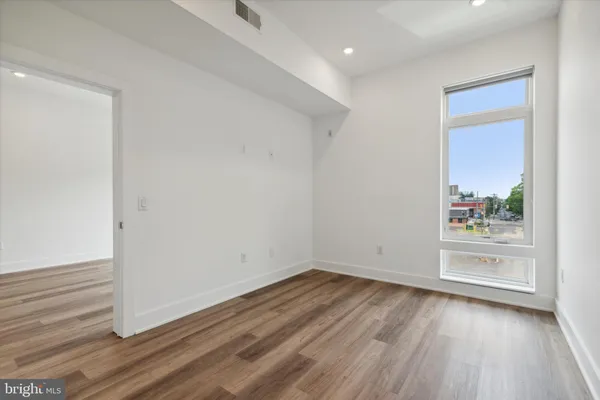 a view of empty room with wooden floor