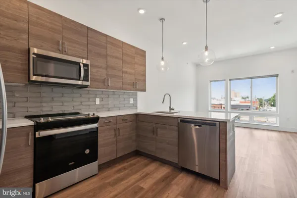 a kitchen with stainless steel appliances a stove a sink and microwave
