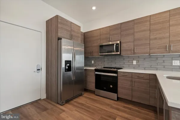 a kitchen with stainless steel appliances granite countertop a stove and a refrigerator