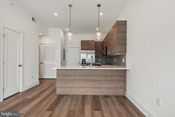a view of large kitchen with kitchen island a sink wooden floor and a large window