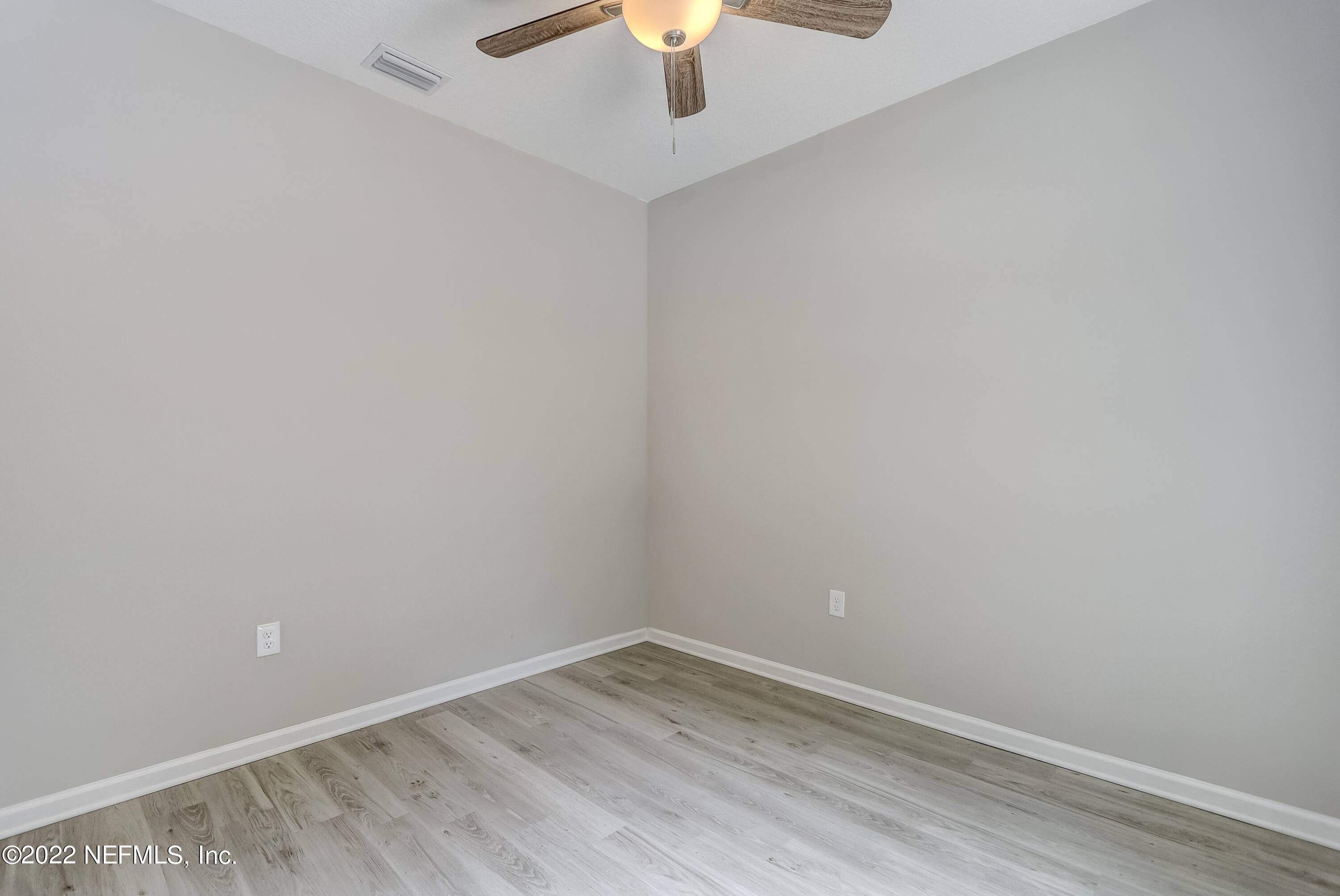 1187 Hatcher Road Middleburg, FL 32068 - Photo 15 of 42 an empty room with a chandelier fan and wooden floor