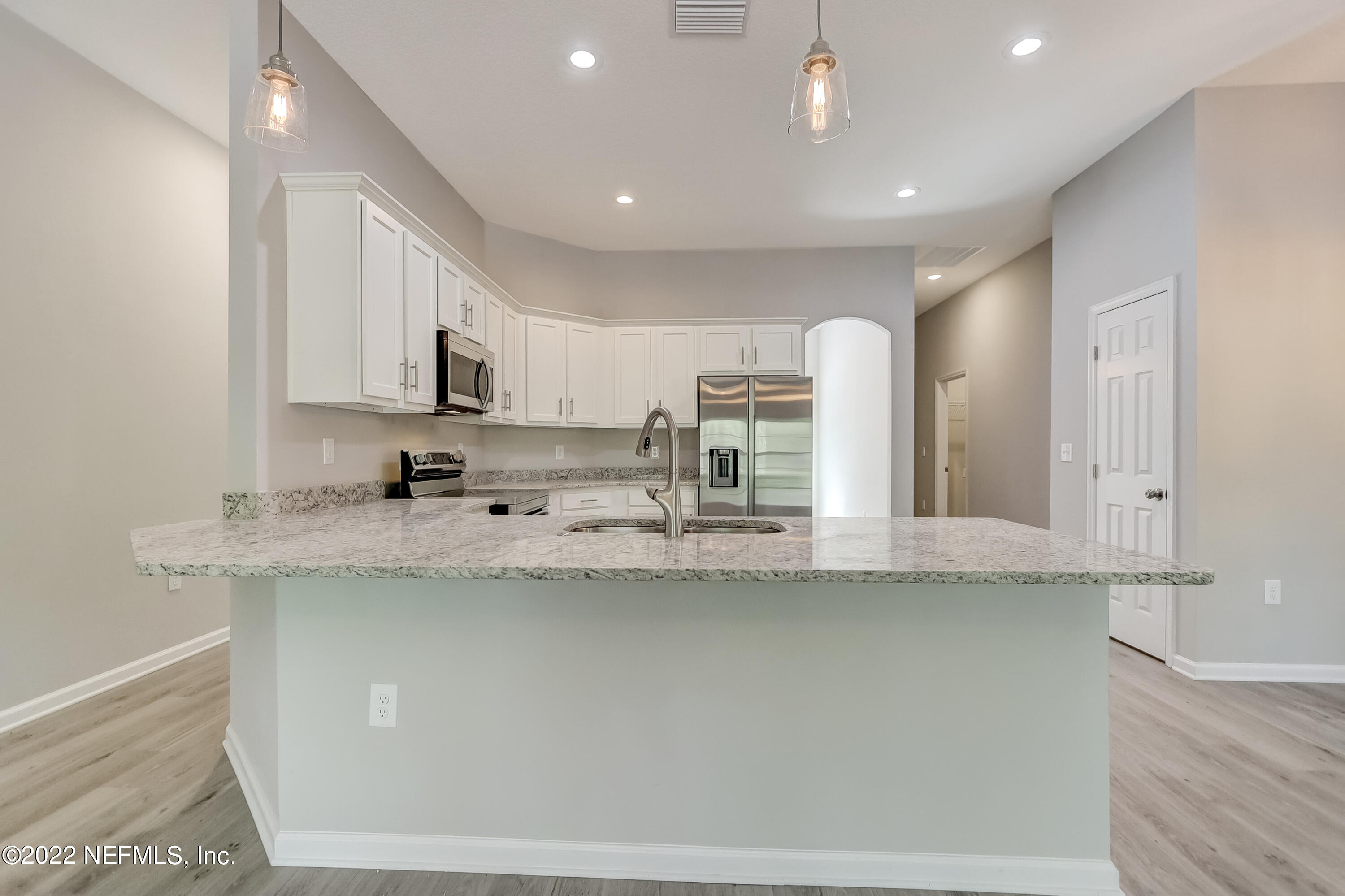1187 Hatcher Road Middleburg, FL 32068 - Photo 18 of 42 a kitchen with stainless steel appliances granite countertop a sink a stove and a refrigerator