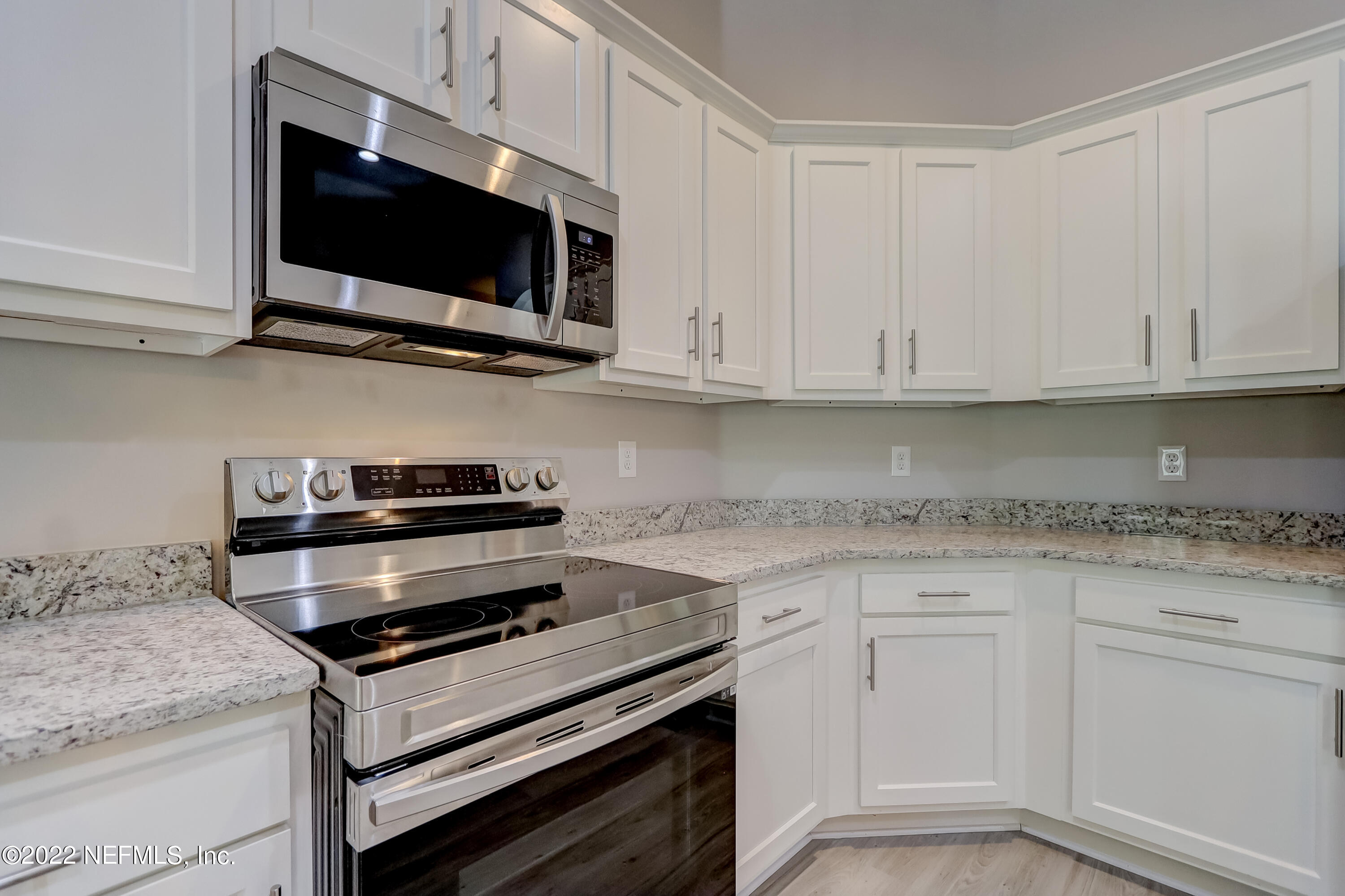 1187 Hatcher Road Middleburg, FL 32068 - Photo 20 of 42 a kitchen with stainless steel appliances granite countertop grey cabinets a stove a sink and dishwasher
