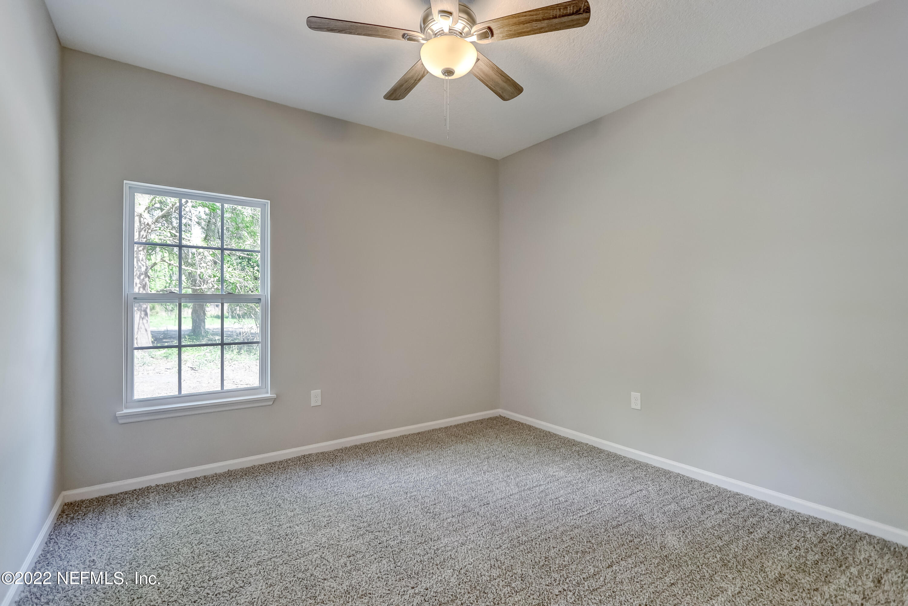 1187 Hatcher Road Middleburg, FL 32068 - Photo 34 of 42 an empty room with chandelier fan and windows