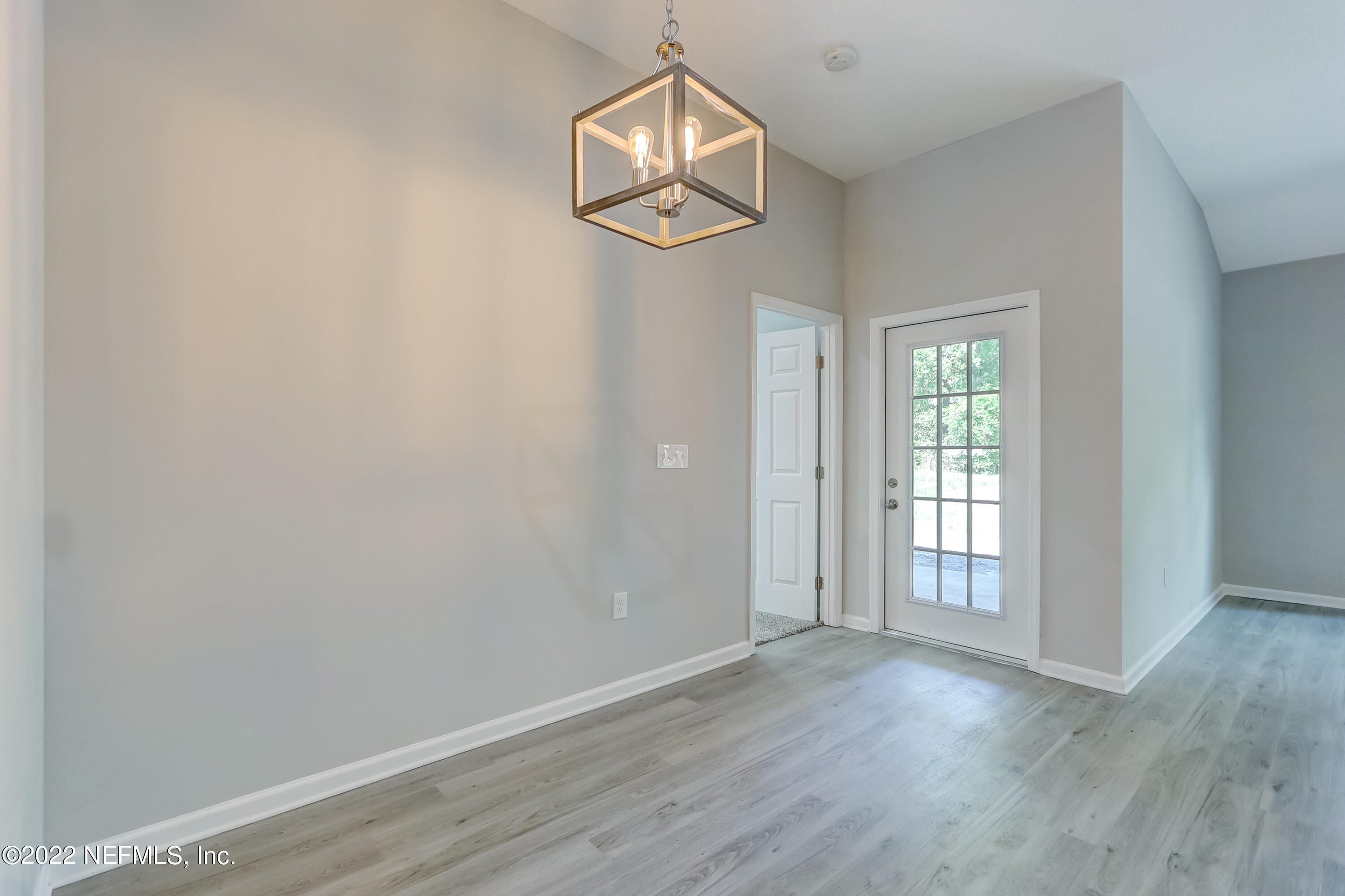 1187 Hatcher Road Middleburg, FL 32068 - Photo 10 of 42 an empty room with wooden floor cabinet and windows