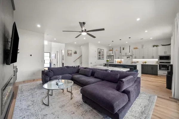 a living room with furniture kitchen view and a flat screen tv