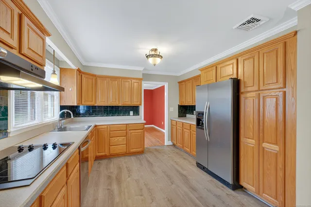 a kitchen with granite countertop a refrigerator stove and sink
