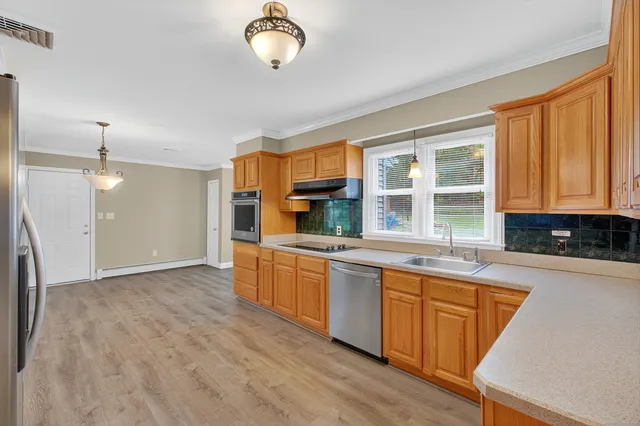 a large kitchen with stainless steel appliances granite countertop a stove and a sink