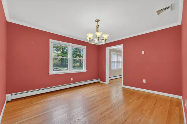 a view of livingroom with window wooden floor and chandelier