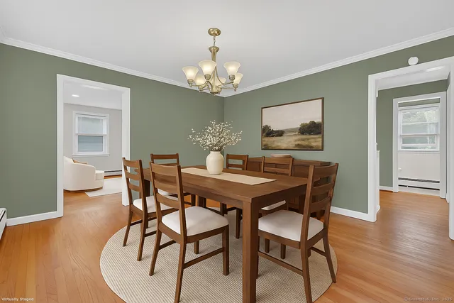 a view of a dining room with furniture wooden floor and chandelier
